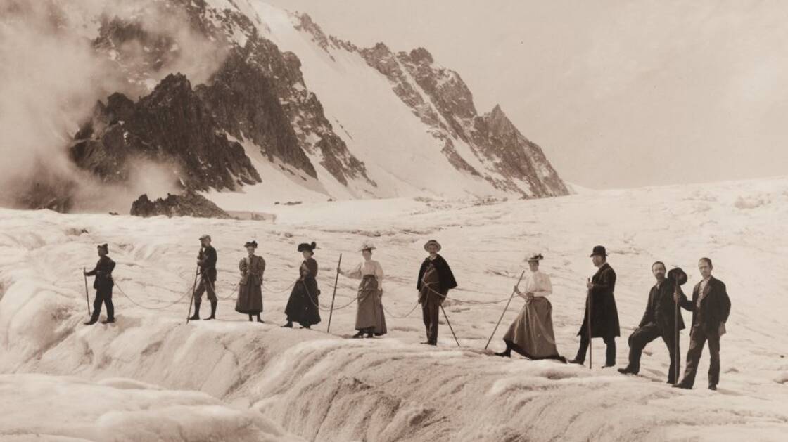 Historische Fotografie einer Gruppe Reisender in den verschneiten Bergen.