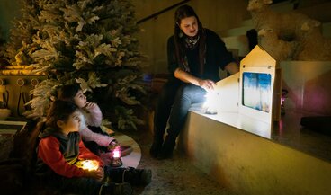 Kinder hören die Weihnachtsgeschichte im Advents-Atelier.